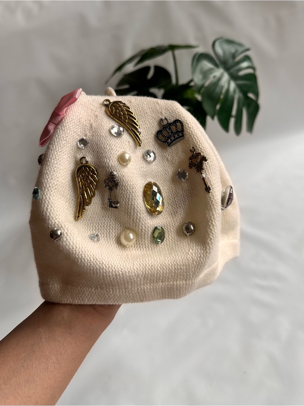 Claire's Cream Beanie Hat with Gold Wing, Crown & Jewel Charms